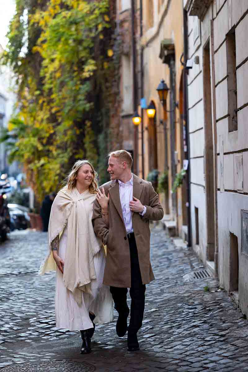 Cinematic style couple on cobblestone alleyway streets holding on to each other while Rome photoshoot in Italy