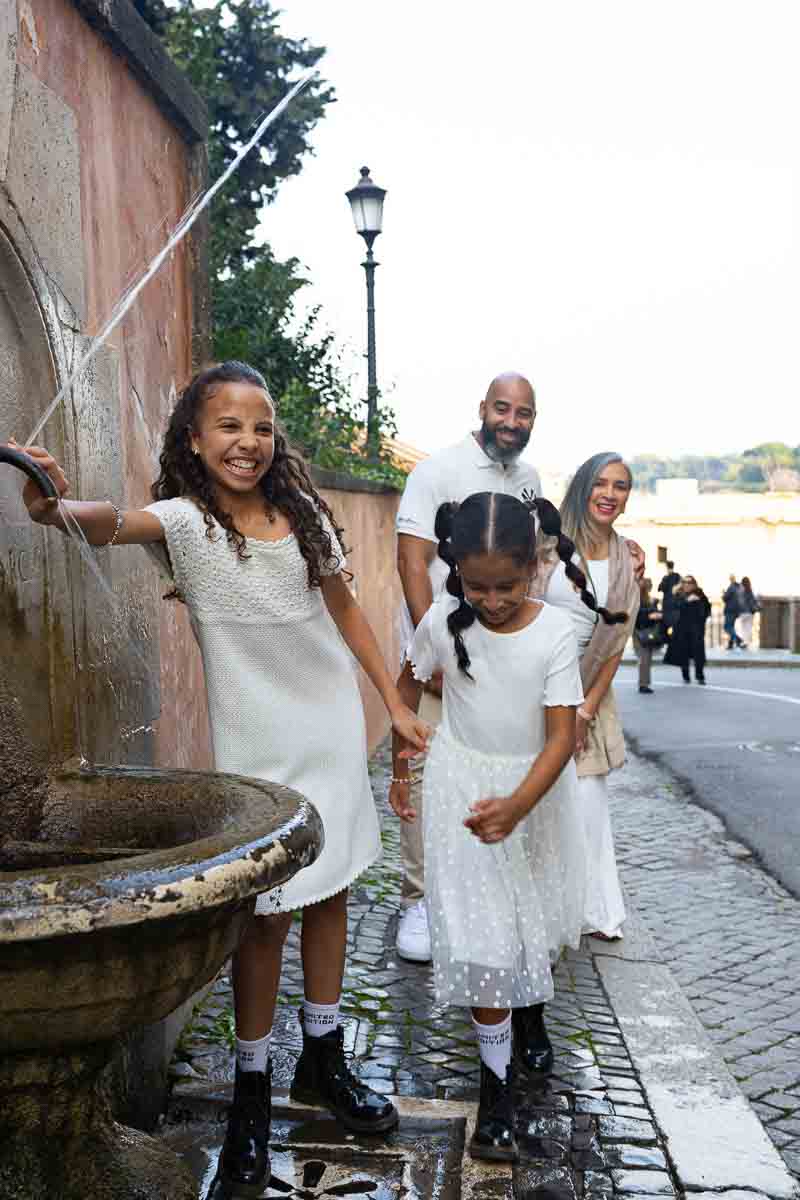 Candid shot of kids running through a fountain during a photoshoot on Capitoline Hill