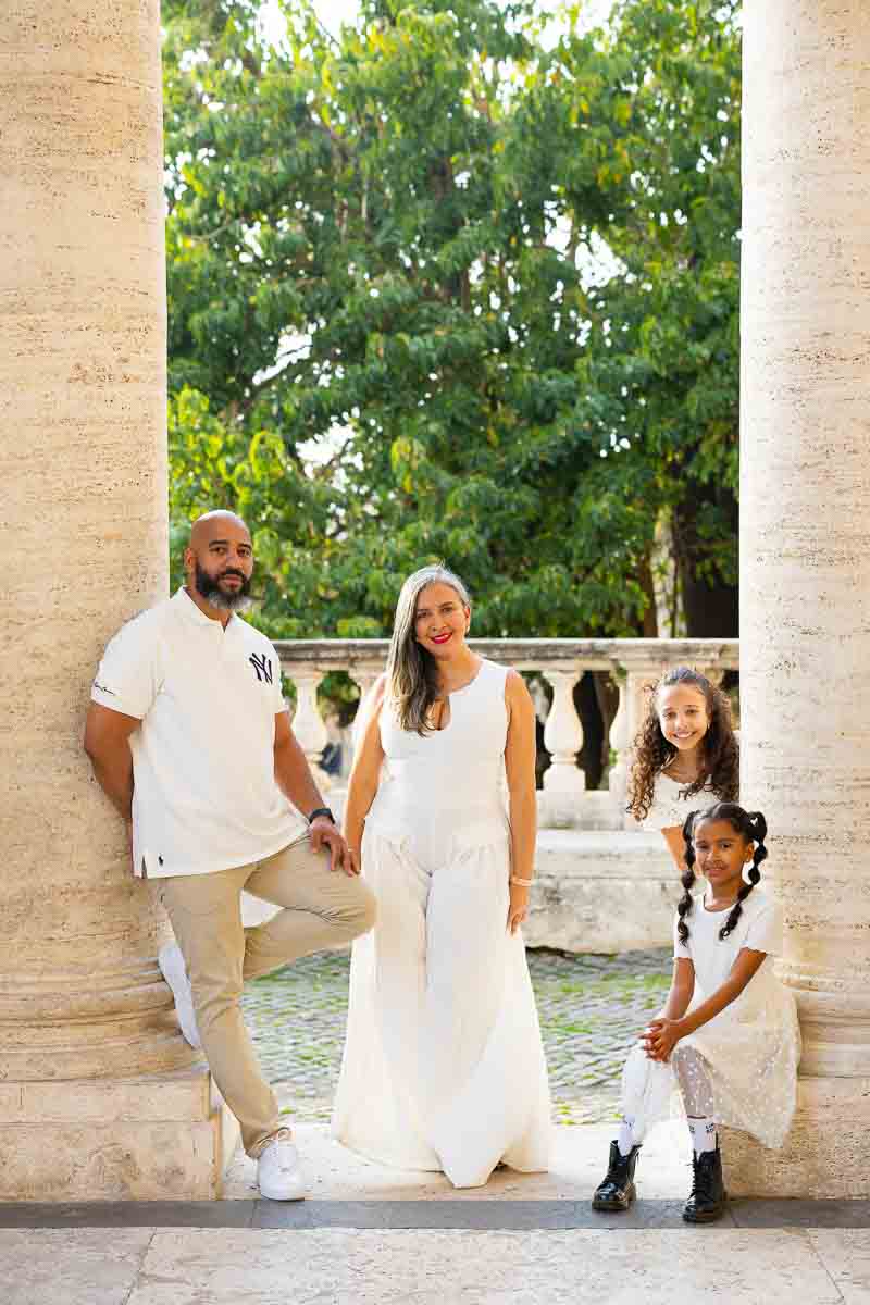 Formal portrait shot under Roman portico columns with architectural details visible