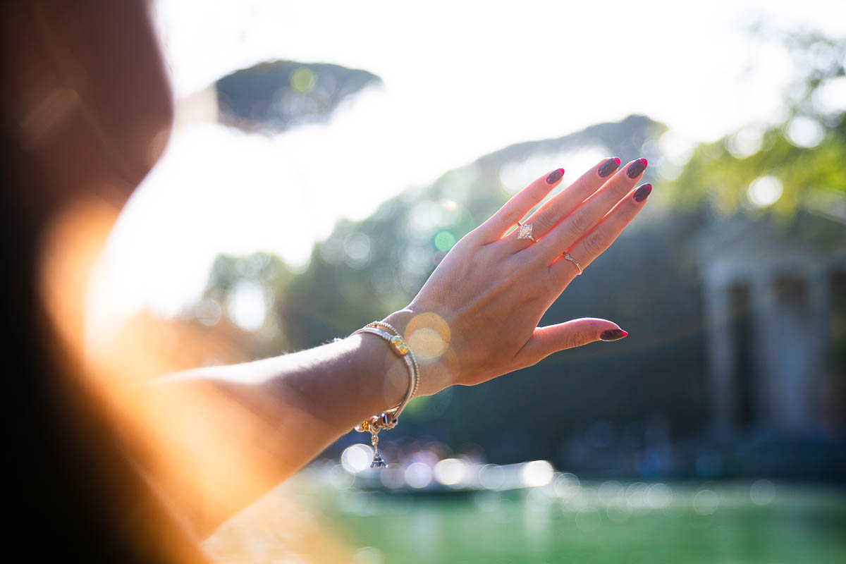 Looking at the diamond engagement ring photographed against the sun shining light 