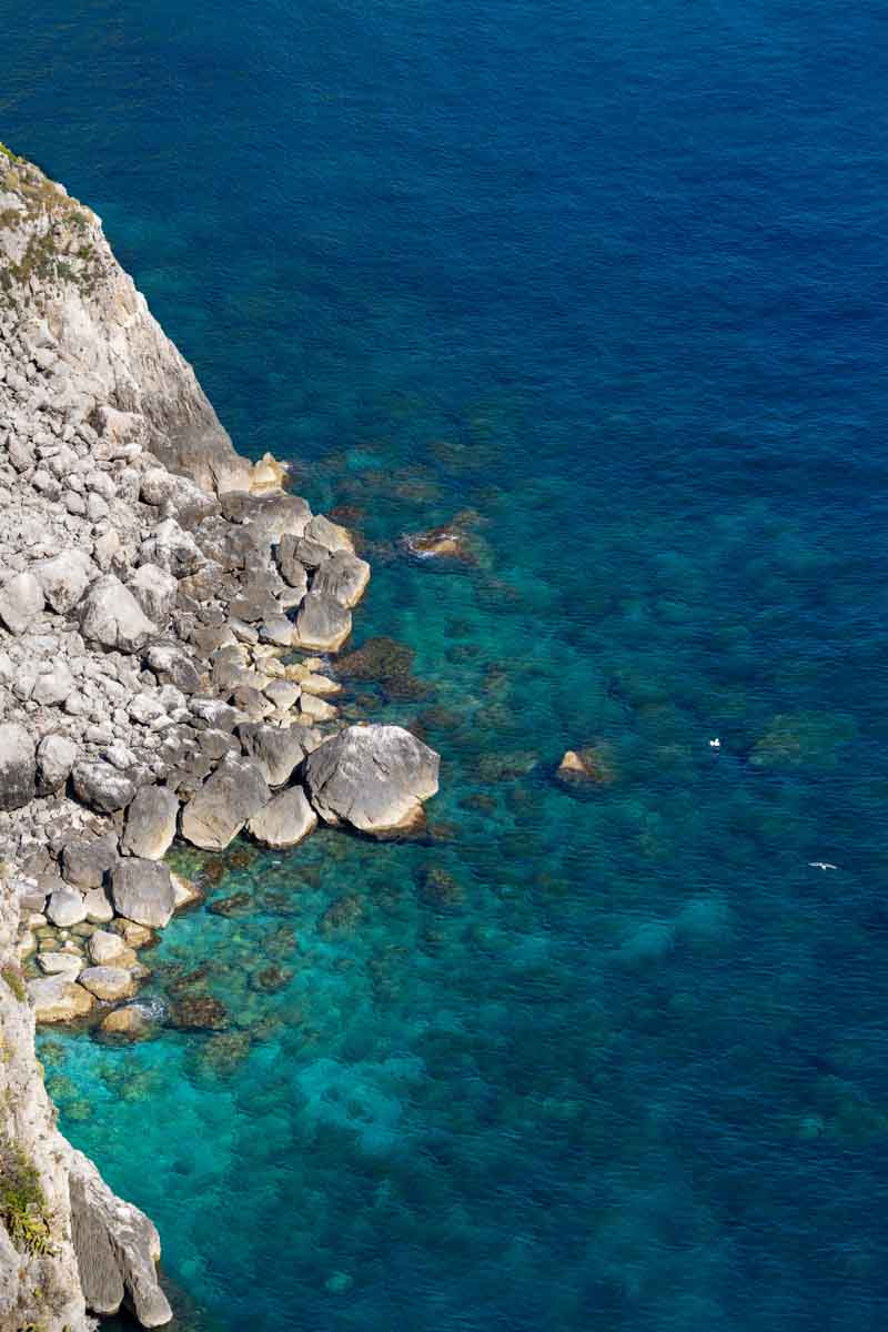View of turquoise sea water photographed from above showing different level depths 