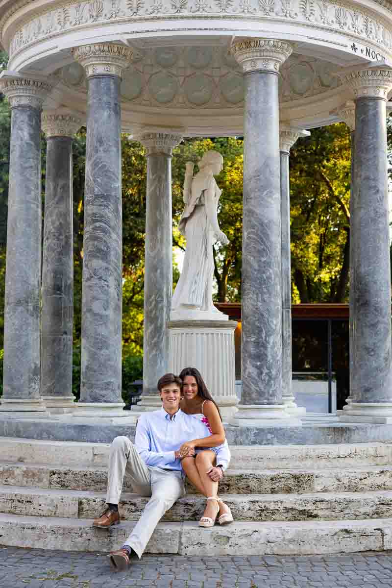 Taking pictures while sitting down on the marble steps of a typical roman landmark 