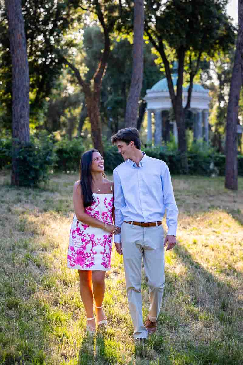 Walking together in the park and holding hands as just engaged couple during beautiful golden light 