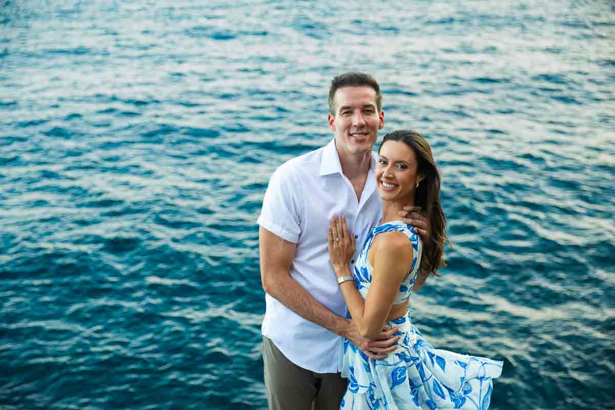 Seaside couple photography session where they are posing by the water as backdrop 