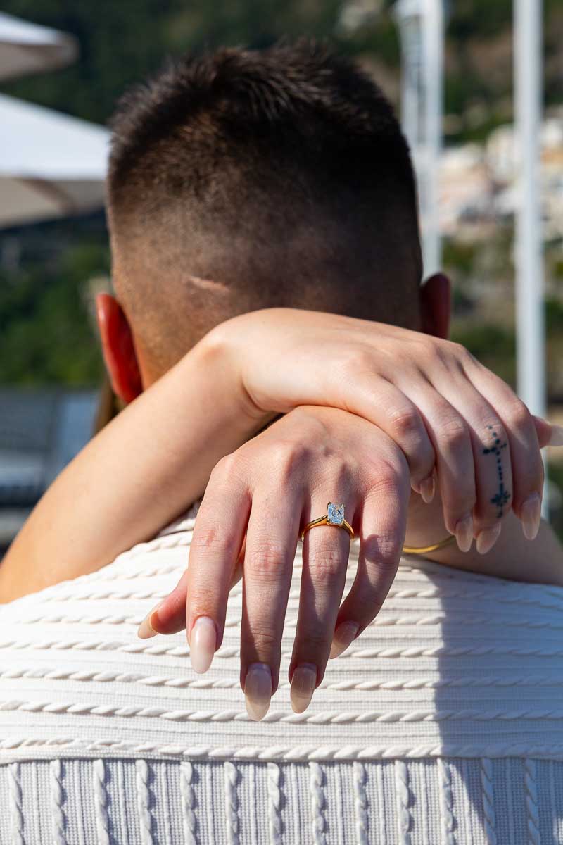 Close-up engagement ring portrait showing the newly engaged woman’s hands resting on her partner’s shoulders during an intimate couples photoshoot in southern Italy