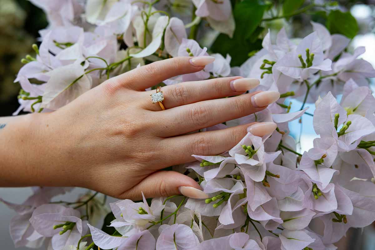 Diamond engagement ring resting delicately among flowers, capturing an elegant detail from a romantic marriage in Italy
