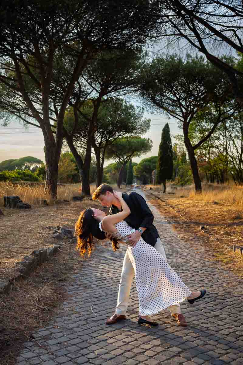 Romantic dip beneath warm sunset light as the couple embraces during a golden hour photography session in the Italian countryside