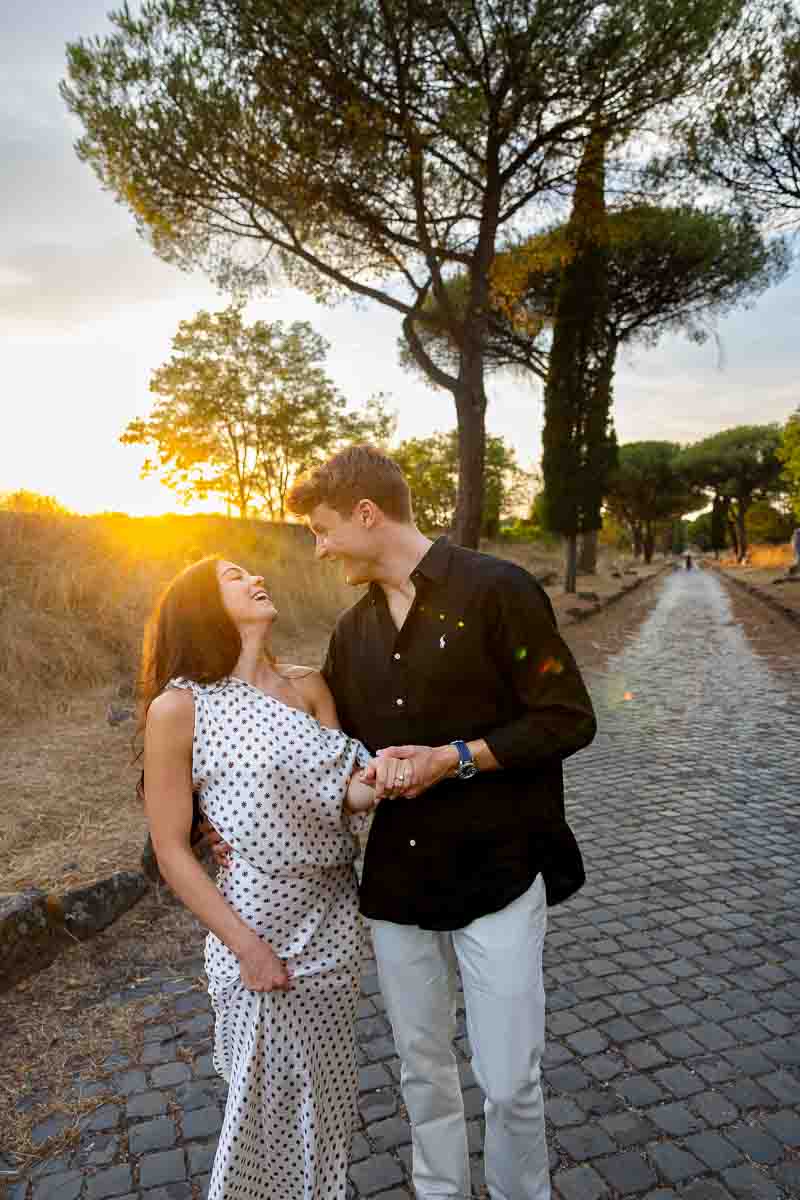 Intimate portrait of two newly engaged lovers standing close together in glowing evening sunlight during a sunset photoshoot near Rome