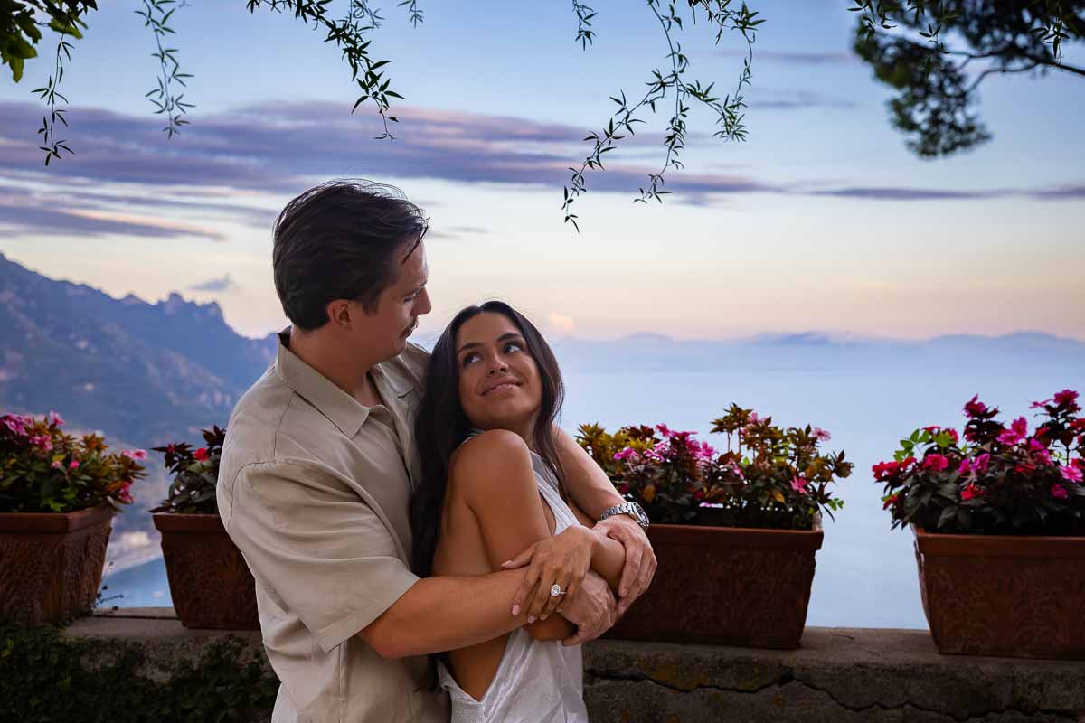 An elegant couple portrait embraced and looking at each other over the coastal scenery during a Ravello sunset marriage proposal.