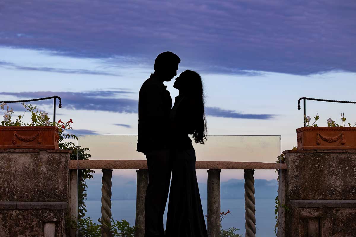 An artistic silhouette photograph capturing a couple against the deep, intense colors of an authentic Mediterranean blue hour sky.