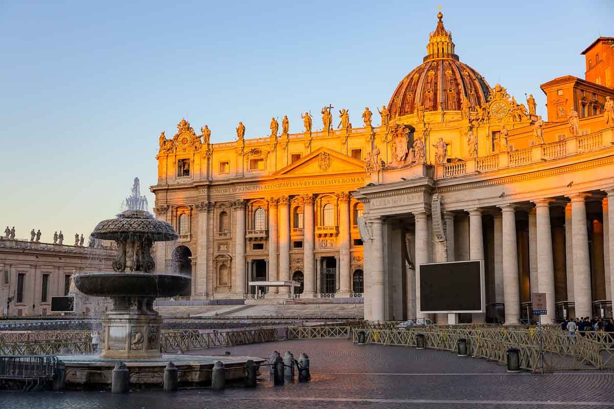 Morning perspective of an empty Roman piazza showing the historic church exterior under early sunrise light.