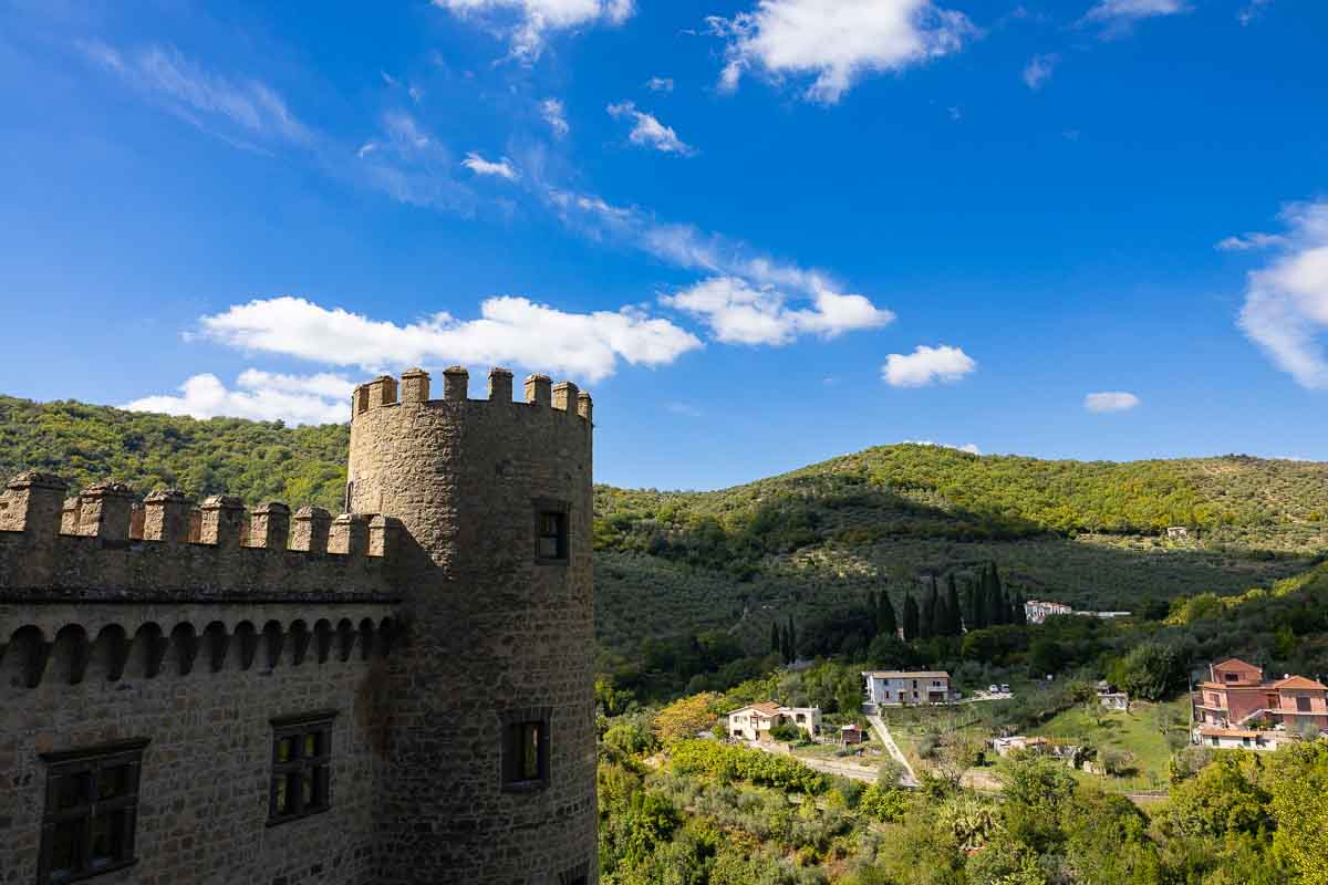 An exterior architectural view looking up at the medieval stone fortress walls.