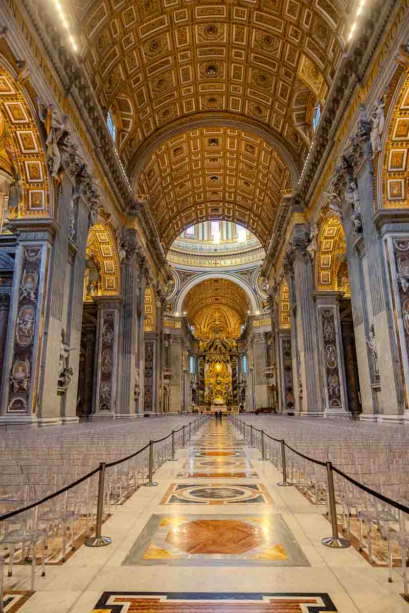 Interior architectural perspective of the grand central nave aisle leading toward the ornate papal altar