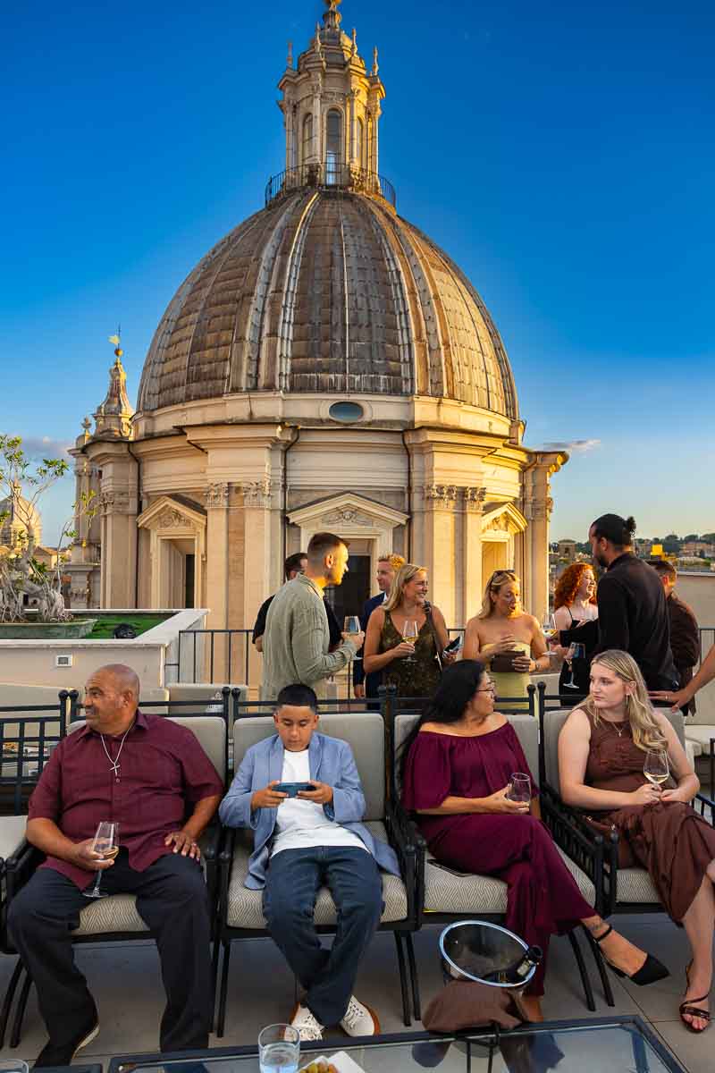 Guests gathered together enjoying the lively atmosphere of the rooftop welcome dinner party.