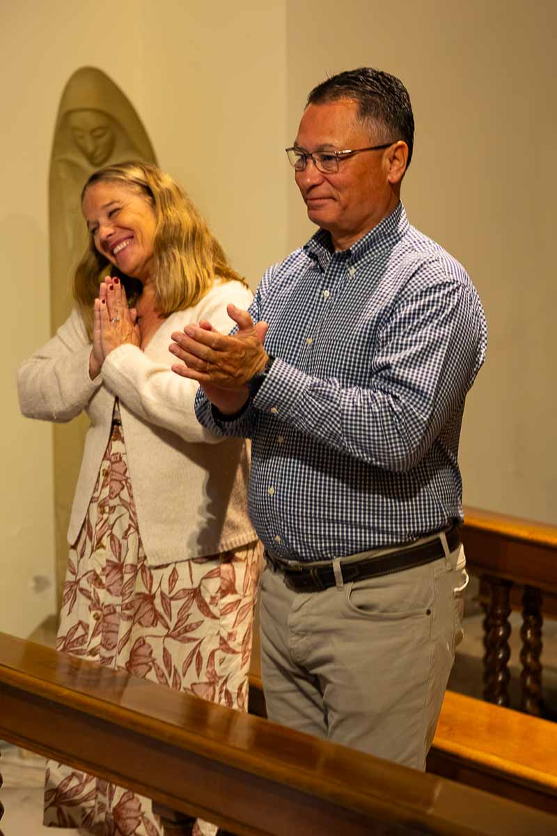 Joyful newlyweds holding hands while sharing a tender look immediately following their commemorative service