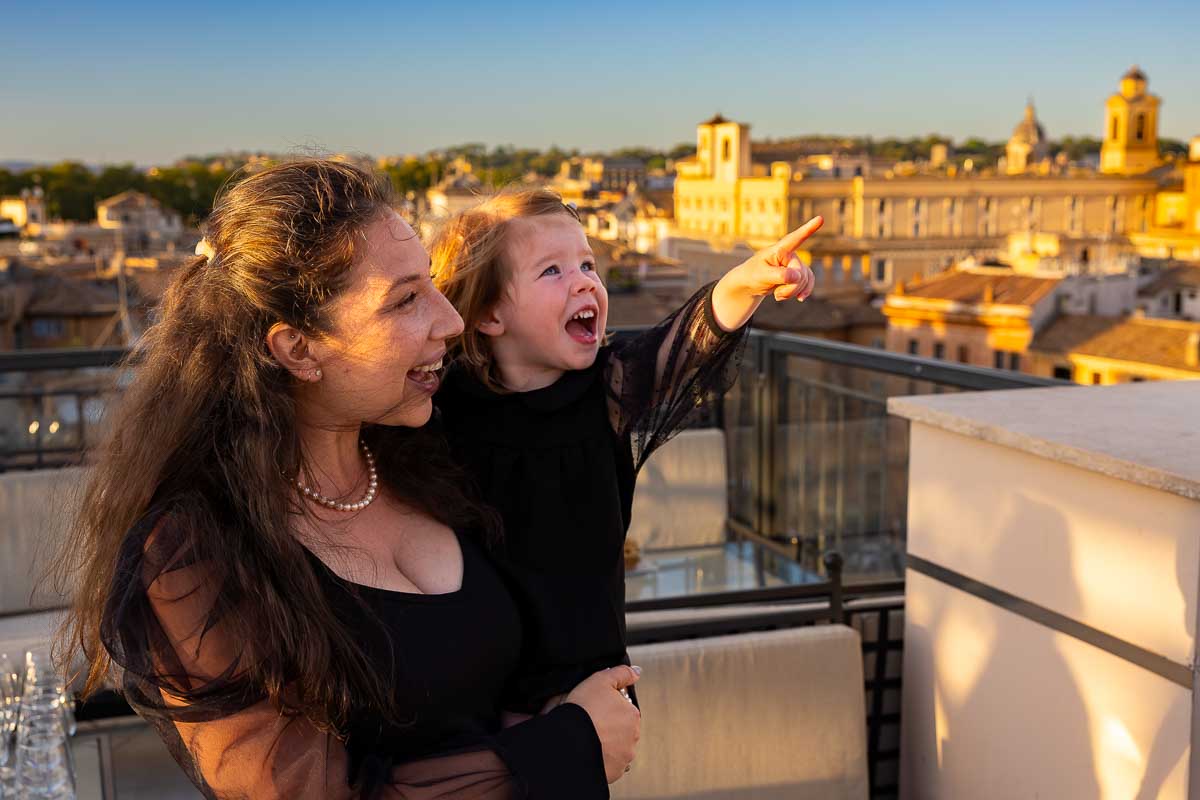 A playful moment with a guest pointing up toward the colorful sunset clouds over Rome.