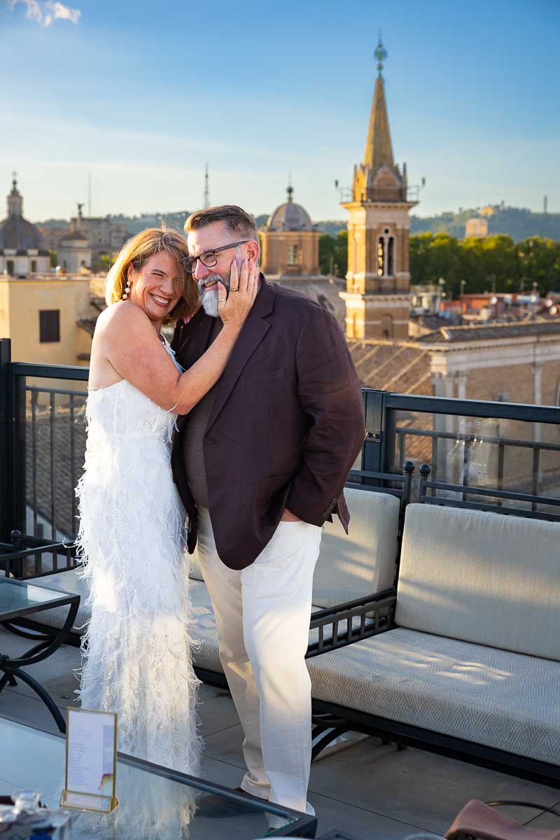 The happy couple posing for pictures together on the terrace overlooking the city.