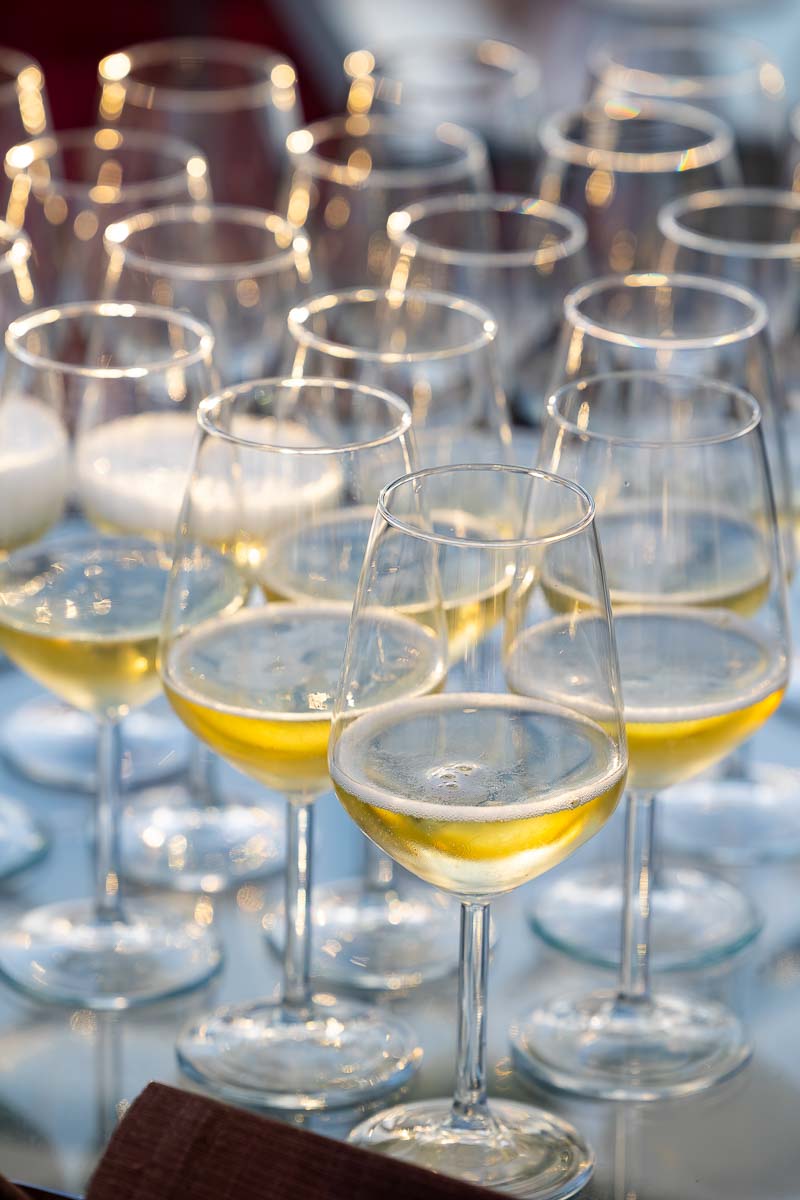 Close-up of elegant wine glasses being filled during a Roman rooftop reception.