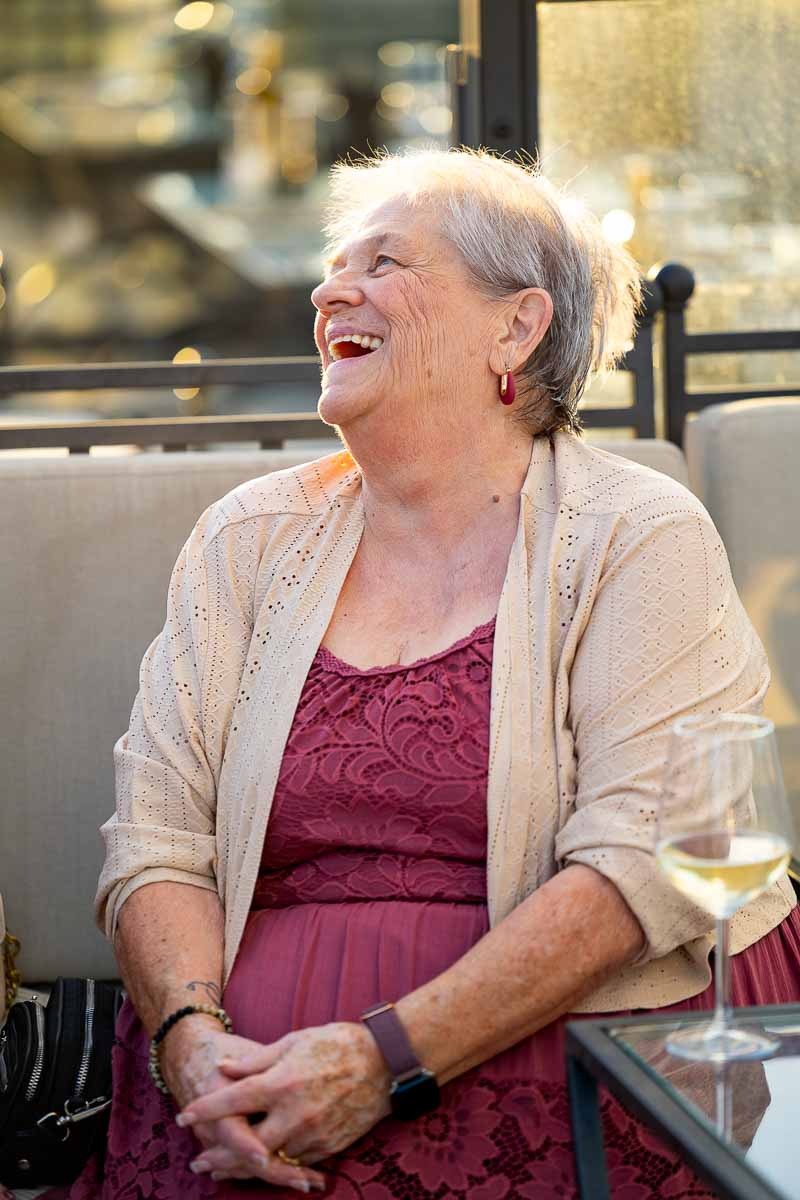 A happy, smiling portrait of a female guest enjoying the lively evening conversations.