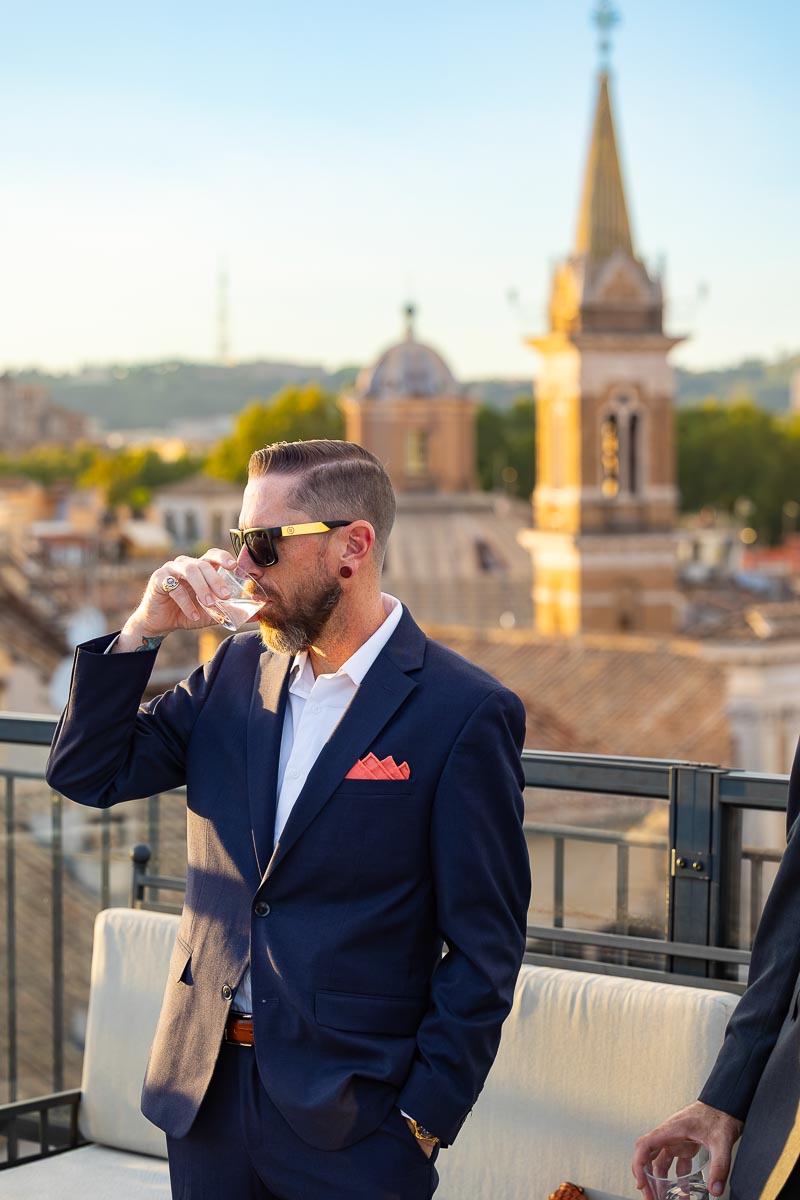 A candid moment of a guest sipping a refreshing drink during the rooftop aperitif.