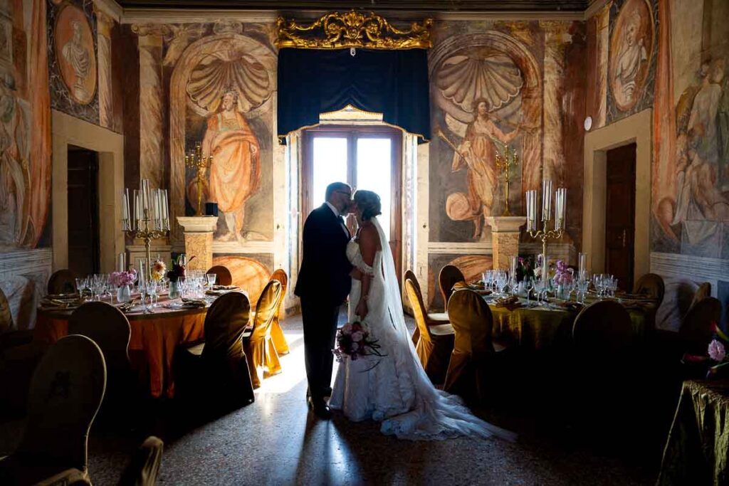 A quiet, romantic moment shared between the couple inside the frescoed palace hall. Artistic destination wed photography session