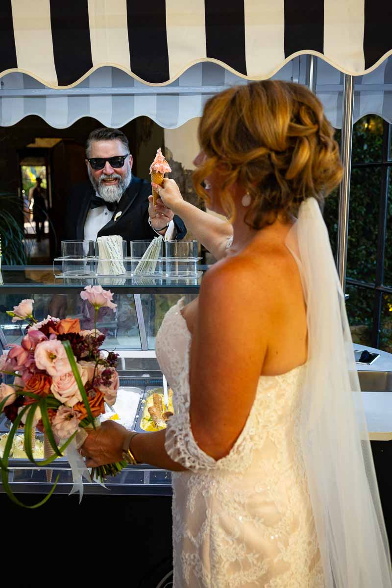A playful moment showing the groom serving Italian ice cream to his smiling bride.
