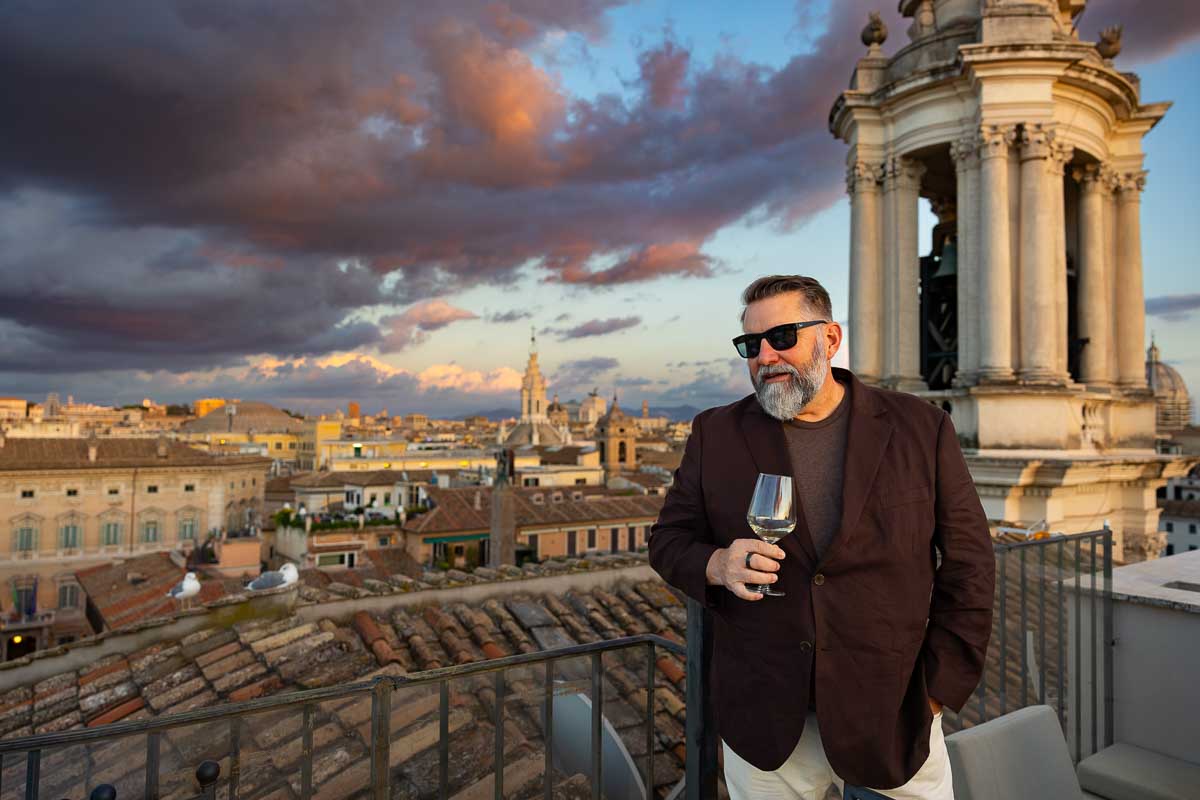 A portrait of the groom-to-be holding a glass during the welcome dinner party.