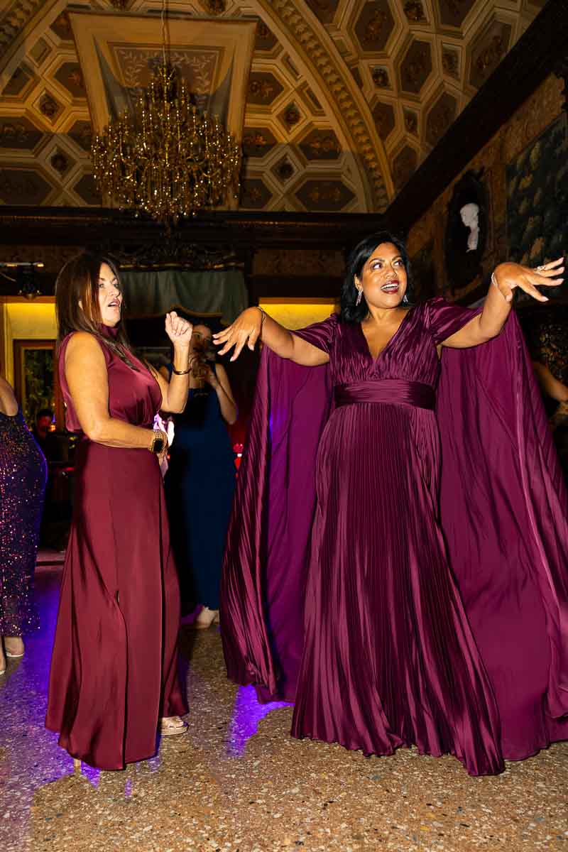 Couples dancing slowly together as the venue lighting transitions to warmer amber tones.