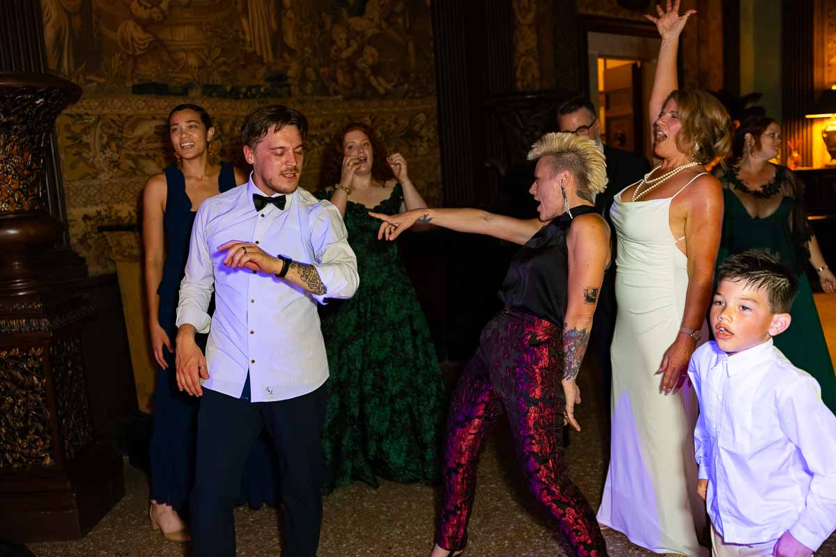 A group of guests cheering and forming a circle around the dancing couple.