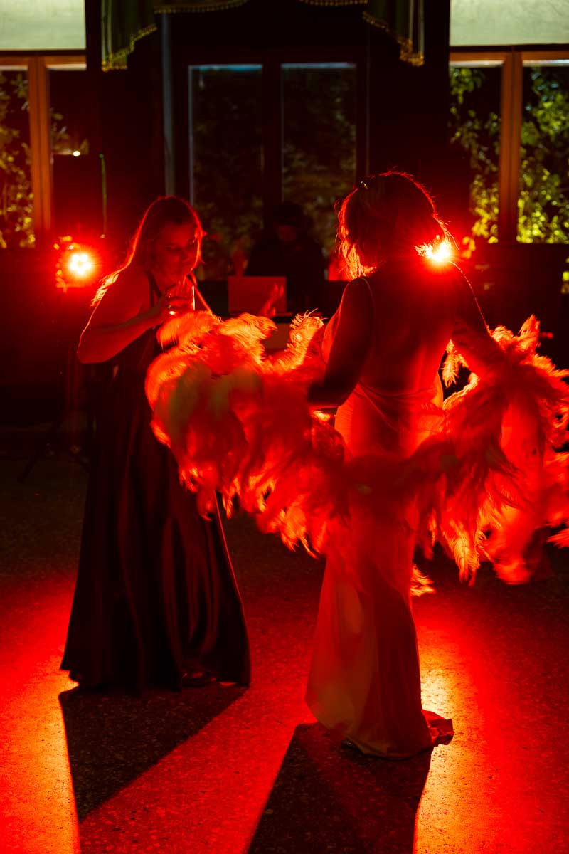 An atmospheric shot of the energetic crowd dancing under a dramatic red light effect on the ballroom floor.